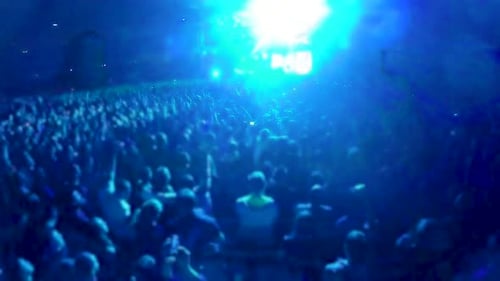 Crowd of People Standing and Jumping in Front of Big Stage at Stadium, Concert