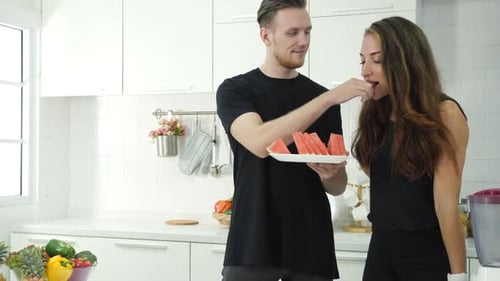 Young Couple Sharing Watermelon in Bright Kitchen