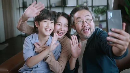Laughing Family Poses for Smartphone Selfie Together