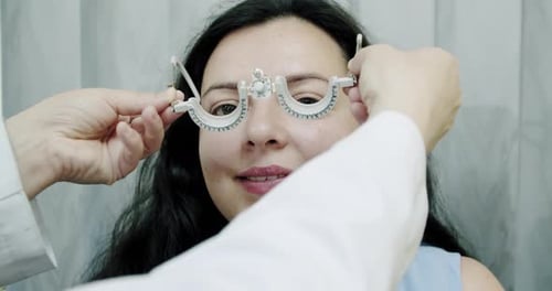 Nahaufnahme der Sehkraft für junge Frauen mit optischem Phoropter. Frau macht Sehtest langsam