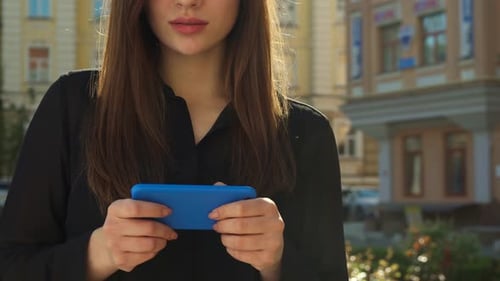 Woman Using Smartphone in Urban Environment on Sunny Day