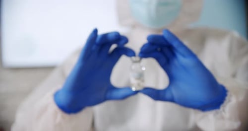 Blured Doctor's Hand Holds Ampoule Vaccine Bottle at the Hospital