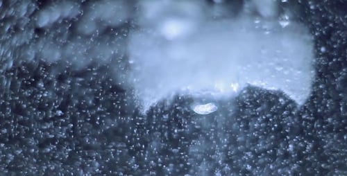 Eiswürfel schmilzt in heißem Wasser