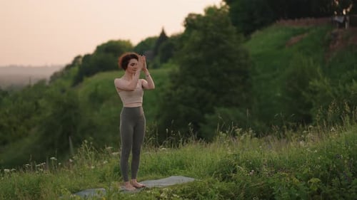 Graceful Woman Practicing Yoga in a Rural Landscape
