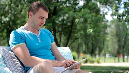 Young Adult Relaxing with Tablet in Park
