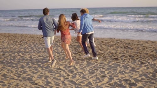 Young People Running On The Beach