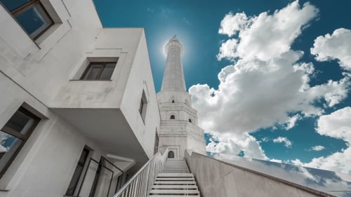 White Tower of the Mosque Before the Sun on a Background of Blue Sky and Clouds. Kazakhstan