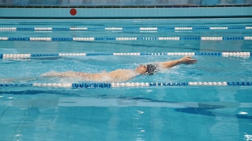 Swimmer Practicing the Crawl Stroke in Indoor Pool