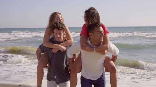 Fun Couples Piggyback Ride on Beautiful Beach