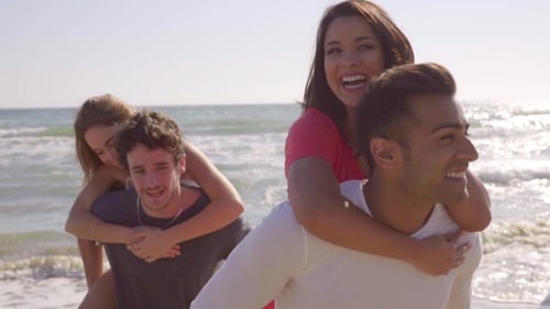 Young Adults Enjoying Piggyback Rides on Beach