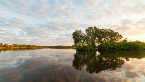 Serene River Reflecting Clouds at Golden Sunrise
