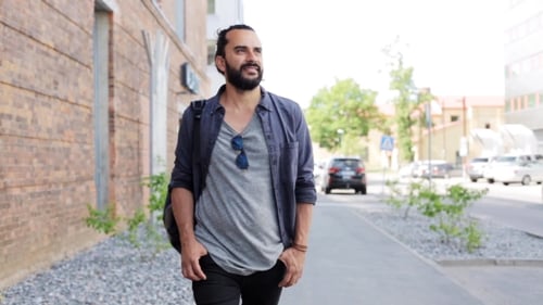 Man With Backpack Walking Along City Street 19
