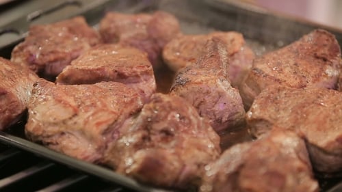 Sizzling Meat Cooking on Tray, Close Up