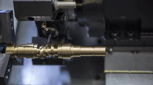 Metal Pipe Being Cut by Machine Lathe