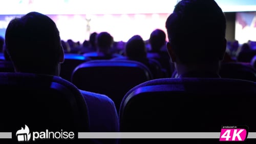 Dark Auditorium of People Listening to Presentation