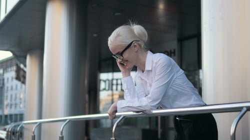Young Business Woman Making a Phone Call Outside Business Center