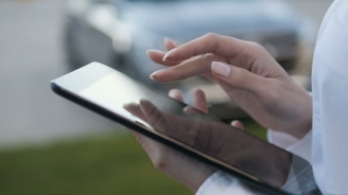 Woman Using Tablet Touchscreen in Urban Setting