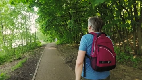Active Adult Hiking and Stretching in Verdant Forest