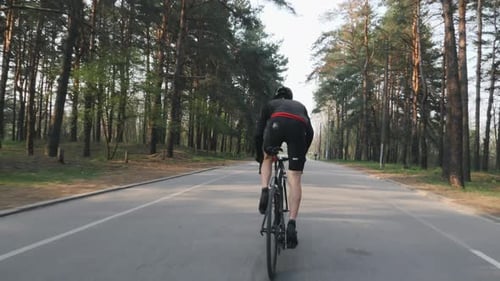 Profi-Radfahrer sprintet im Park aus dem Sattel. Radsport-Training. Radsport-Konzept.