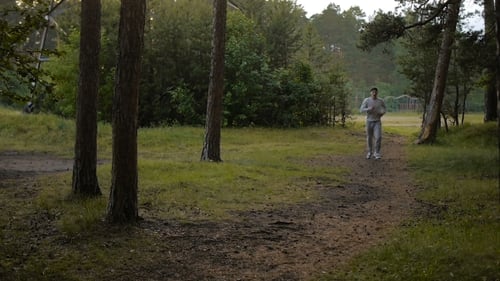 Young Sports Man In The Baseball Cap Runs Through The Woods