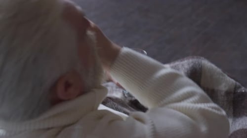 Senior Man Takes Pills with Water Indoors