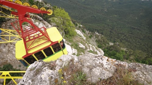 Cable Car Ascending Mountain on Sunny Day