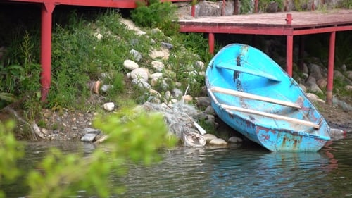 Old Blue Boat Near Red Pier And Tree Branch