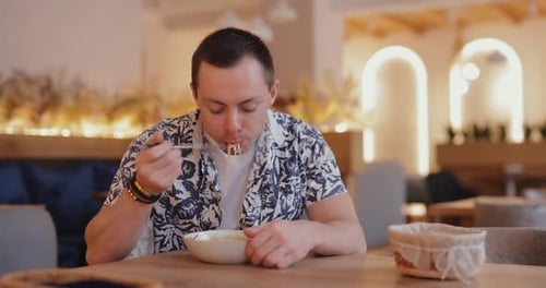 Man Eating Pasta in a Cafe