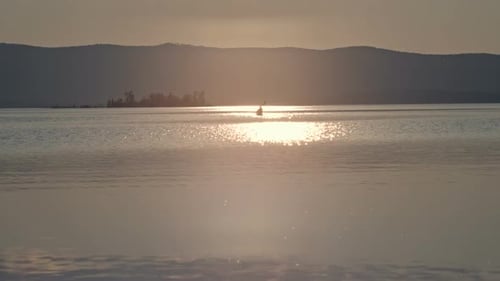 Kayaker Paddling on Lake at Golden Hour