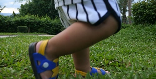 Little Boy's Foot Stepping On The Grass
