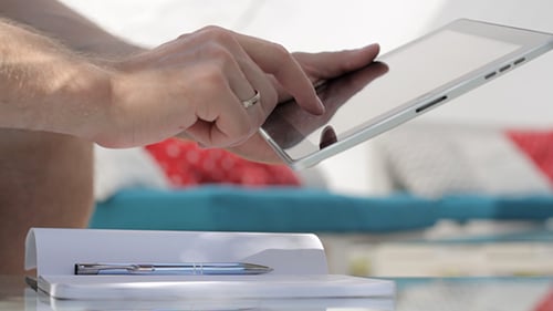 Junger Mann arbeitet auf einem Tablet in der Natur