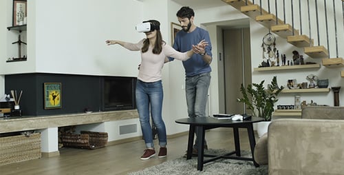 Woman Enjoys Virtual Reality with Man in Living Room