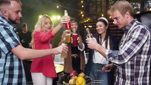 Young People Having Fun on Party Celebration and Clinking Bottles with Colourful Beverages During