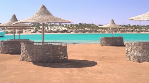 Sun Beds Umbrellas and Bungalows on the Beach By the Azure Sea