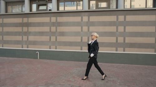 Business Woman Walking And Making a Phone Call Outdoor In City.