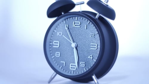 Alarm Clock Ticking Quickly on White Background