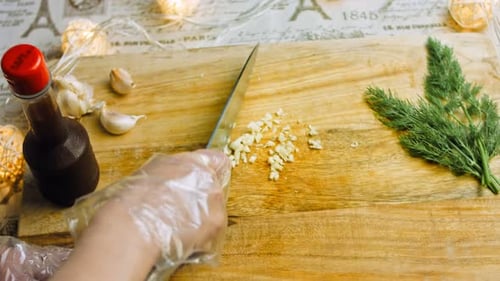 El chef corta un diente de ajo con un cuchillo