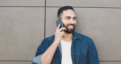 Bearded Man Talking on Smartphone in Urban Setting
