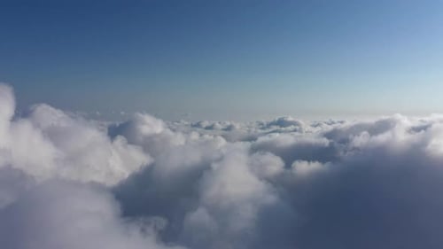 Fluffy Clouds Drifting Beneath a Clear Blue Sky