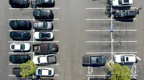 Aerial Top View of Parking Lot at Shopping Mall with Varieties of Colored Vehicles.