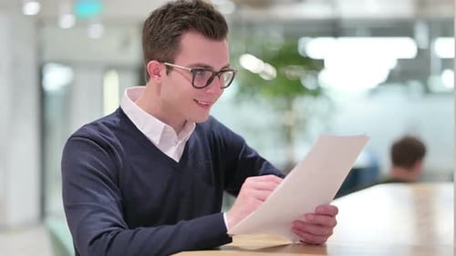 Young Adult Celebrates Reading Good News on Paper