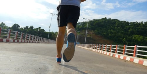 Athletic Man Running on Bridge During the Daytime