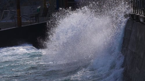 Powerful Waves Crashing Against Concrete Coastal Wall