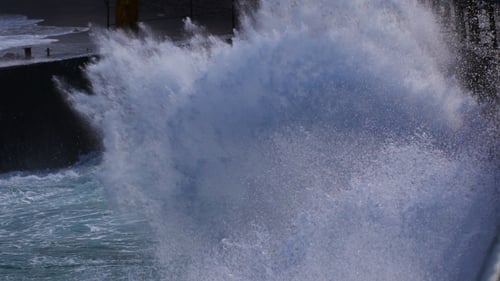 Waves Crashing Against Pier on a Sunny Day