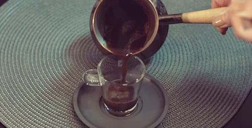 Pouring Traditional Turkish Coffee Into a Glass Cup