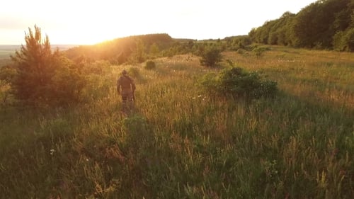 Aerial View: Soldier In Camouflage On The Nature Landscape On Sunset
