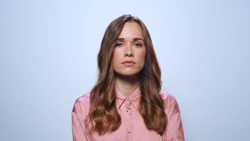 Serious Businesswoman on Blue Background. Woman Looking at Camera in Studio