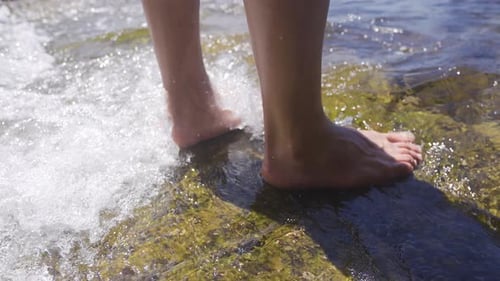 Bare feet touch the sea water.