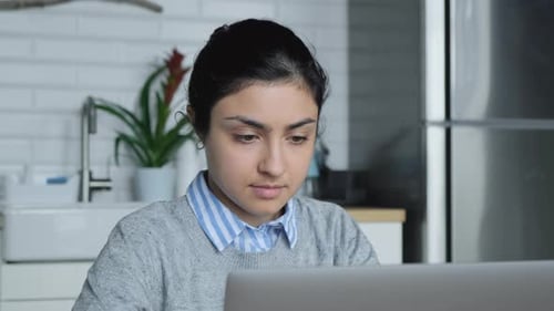 Close-Up Of A Young Indian Woman Working At Home, Doing Tasks On The Computer