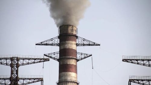 Industrial Smokestack Emitting Gray Smoke in Urban Setting